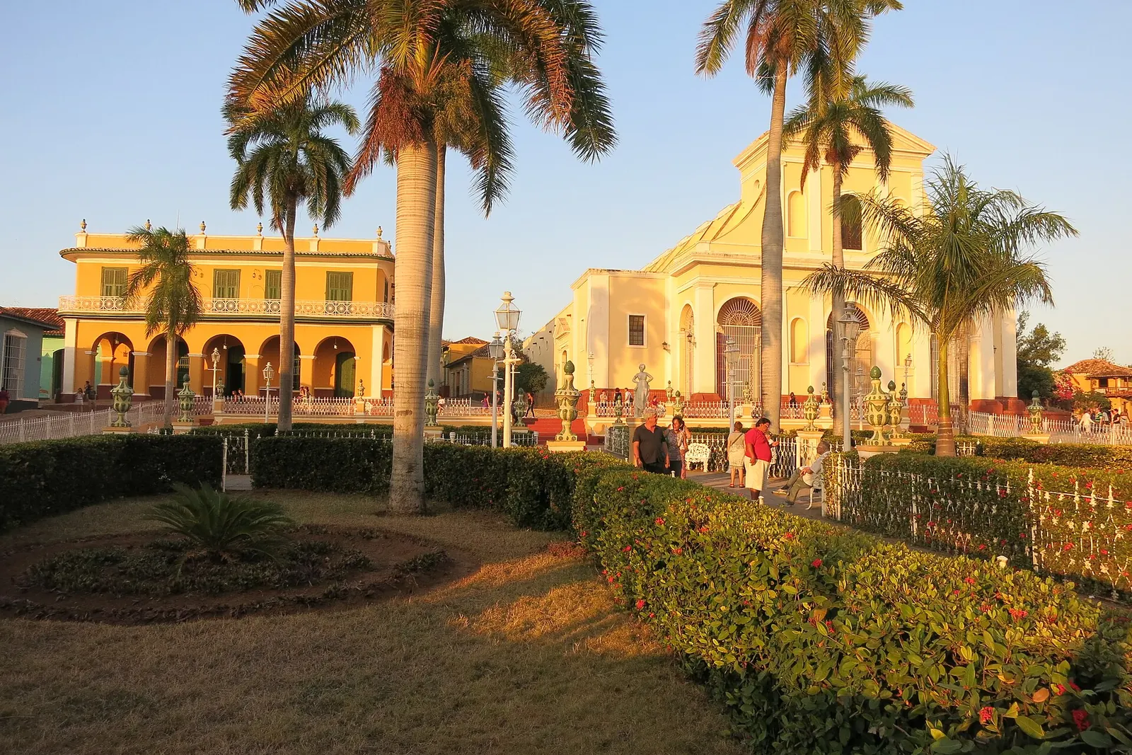 Plaza Mayor de Trinidad al atardecer con palmas reales y la iglesia, Cuba